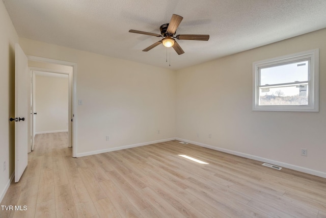 unfurnished room with ceiling fan, light hardwood / wood-style flooring, and a textured ceiling