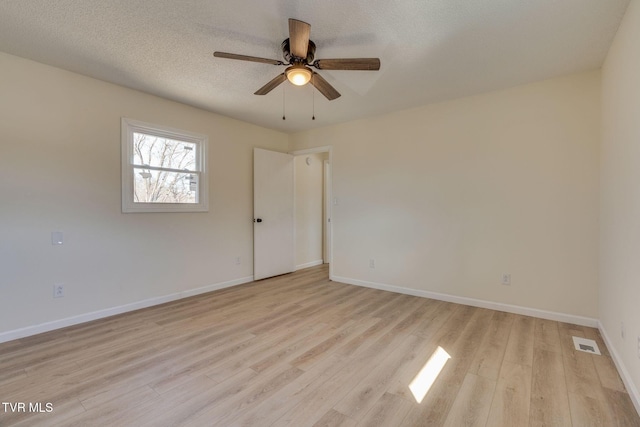 spare room featuring ceiling fan, light hardwood / wood-style flooring, and a textured ceiling