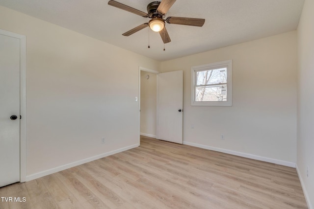 spare room featuring ceiling fan, light hardwood / wood-style flooring, and a textured ceiling