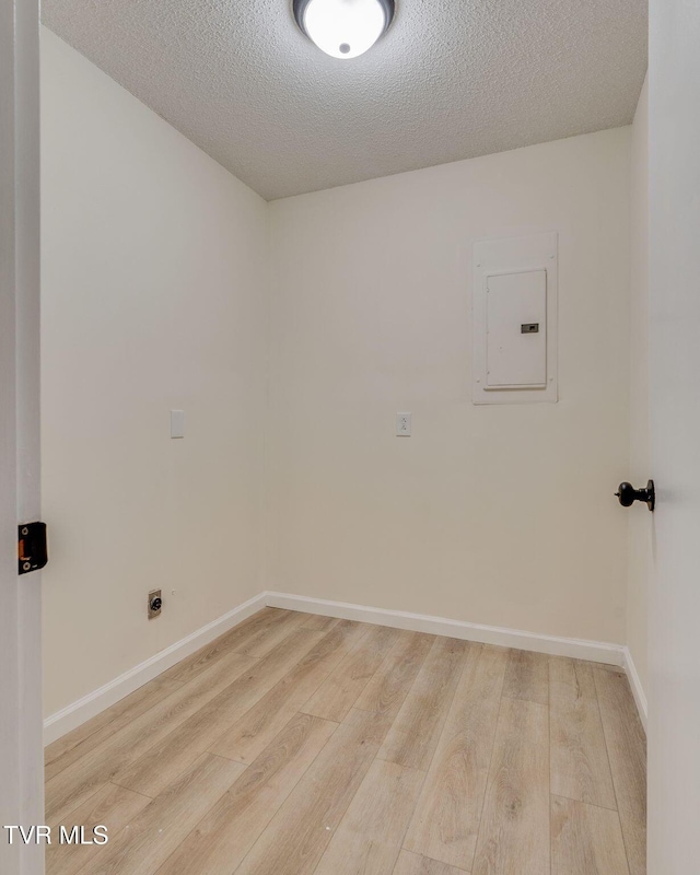 clothes washing area featuring wood-type flooring, electric panel, hookup for an electric dryer, and a textured ceiling