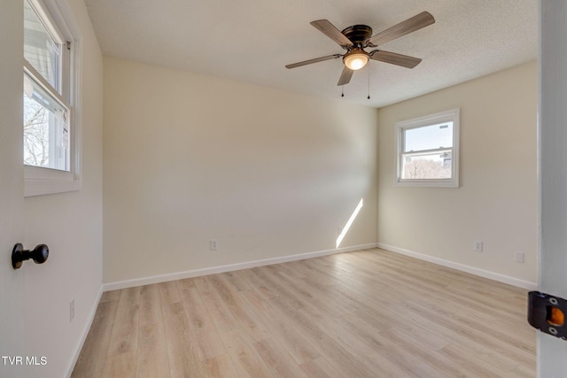 spare room featuring ceiling fan, light hardwood / wood-style flooring, and a textured ceiling