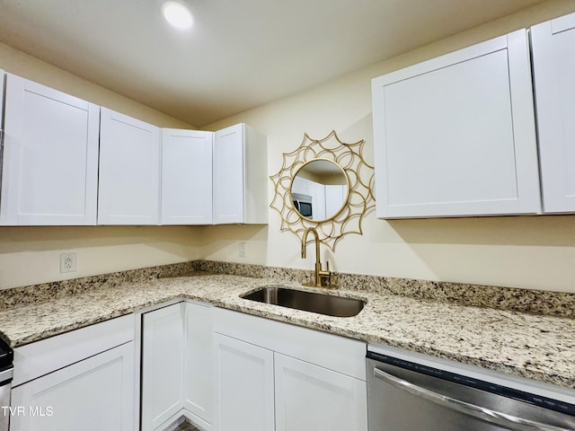 kitchen with light stone countertops, sink, stainless steel dishwasher, and white cabinets