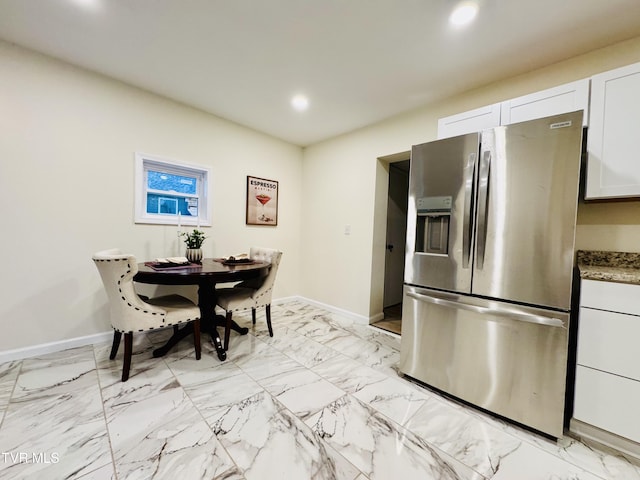 kitchen with white cabinetry and stainless steel refrigerator with ice dispenser