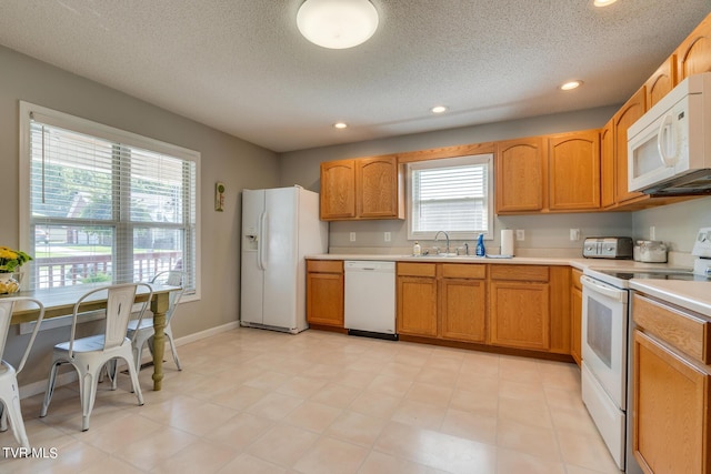 kitchen with sink, a textured ceiling, and white appliances