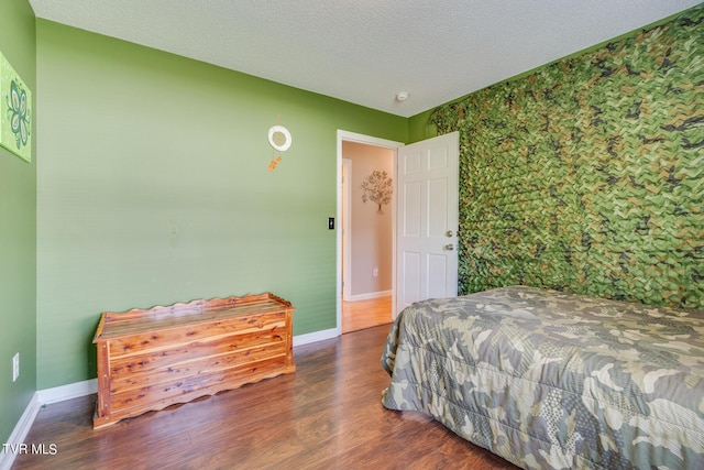 bedroom with a textured ceiling and dark hardwood / wood-style flooring