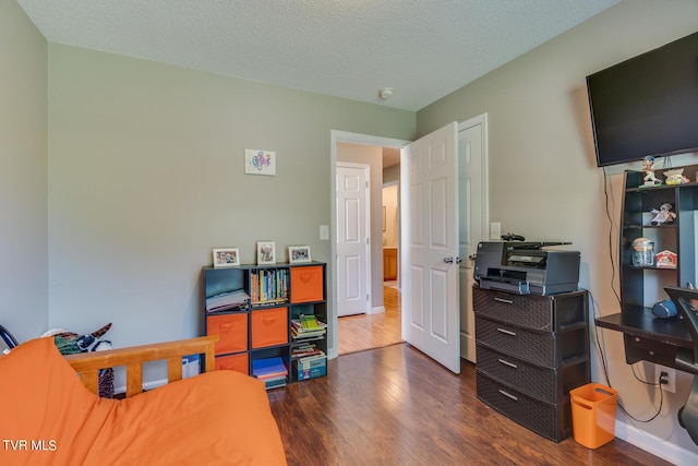 bedroom featuring dark hardwood / wood-style flooring and a textured ceiling