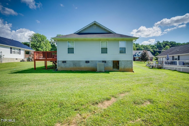 rear view of house with a wooden deck, a yard, and central AC unit