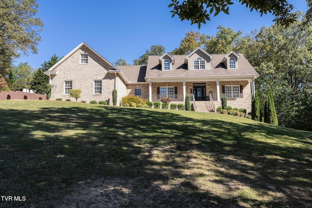 cape cod house with a front yard and a porch