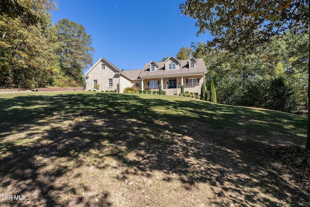 cape cod house with covered porch and a front yard