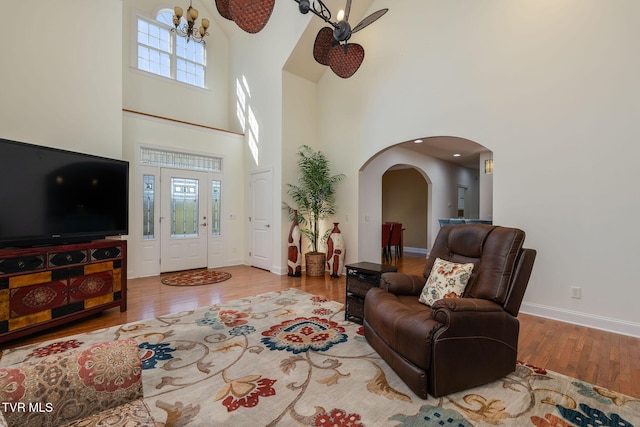 living room featuring hardwood / wood-style floors, a chandelier, and a high ceiling