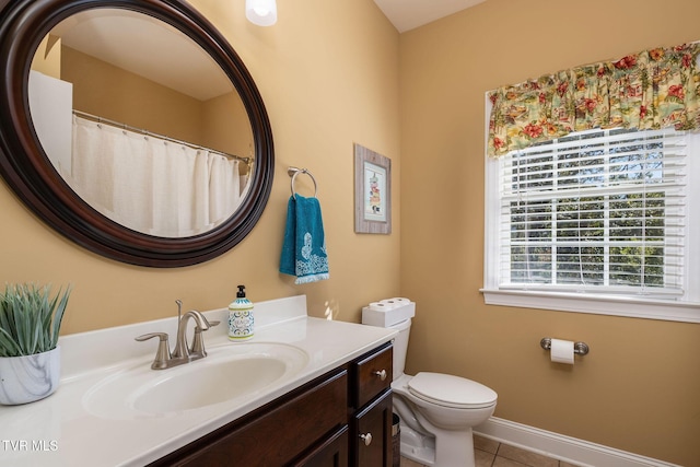 bathroom with tile patterned flooring, vanity, and toilet