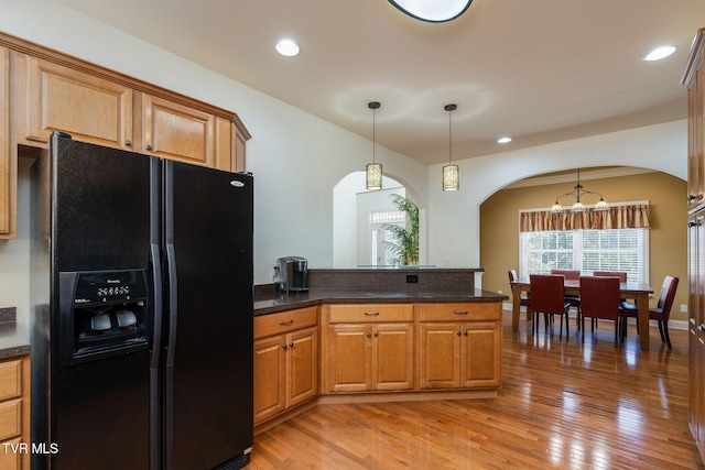 kitchen featuring a chandelier, black fridge with ice dispenser, decorative light fixtures, and light hardwood / wood-style floors