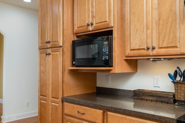 kitchen featuring dark stone countertops and hardwood / wood-style floors