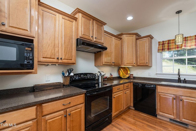 kitchen featuring pendant lighting, sink, light hardwood / wood-style floors, and black appliances