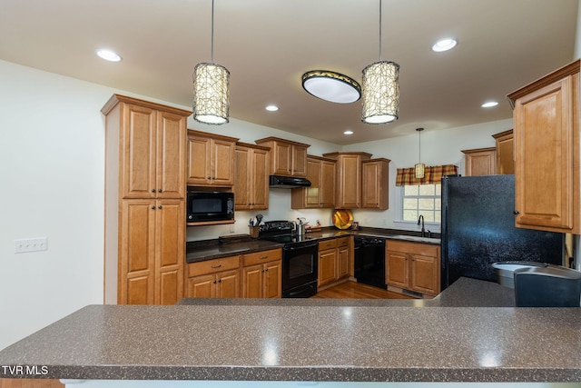 kitchen featuring sink, black appliances, and decorative light fixtures