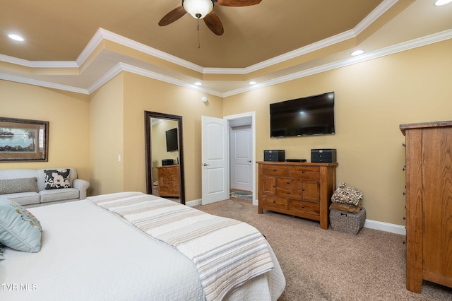 bedroom with light carpet, a tray ceiling, ceiling fan, and crown molding