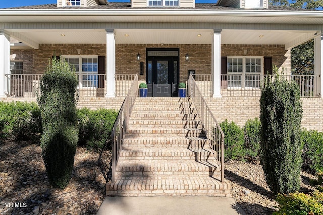 view of exterior entry featuring covered porch