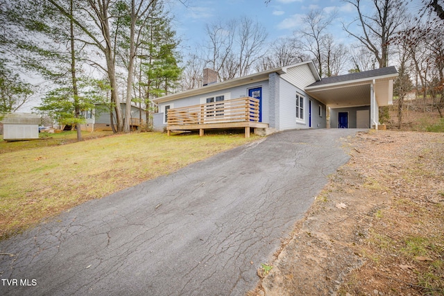 view of front of home with a front yard, a deck, and a carport