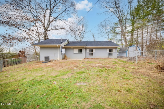 back of house featuring central air condition unit and a yard