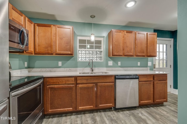 kitchen featuring pendant lighting, sink, wood-type flooring, and stainless steel appliances