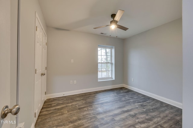 unfurnished room with ceiling fan and dark wood-type flooring