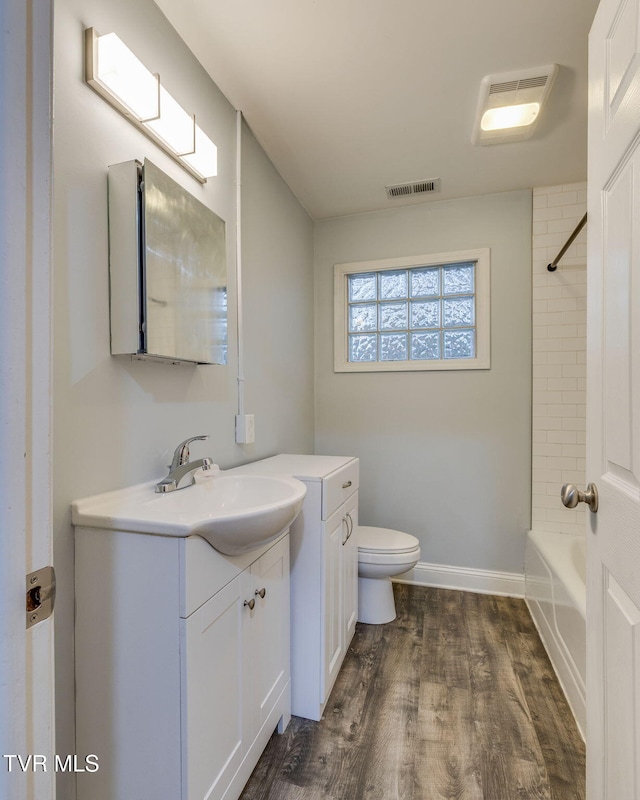 full bathroom featuring vanity, hardwood / wood-style flooring, toilet, and shower / bathtub combination