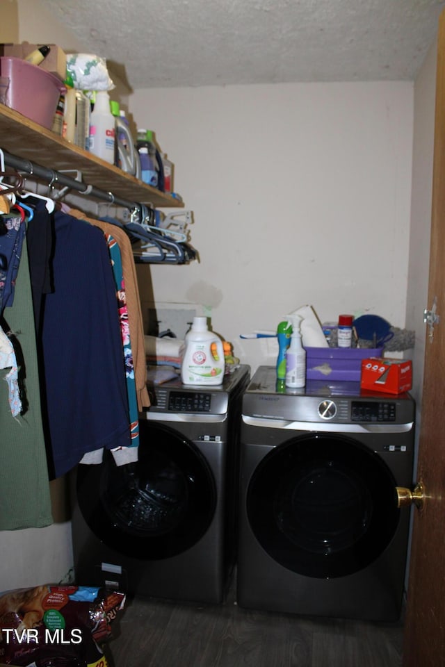 clothes washing area with washing machine and dryer, dark hardwood / wood-style flooring, and a textured ceiling