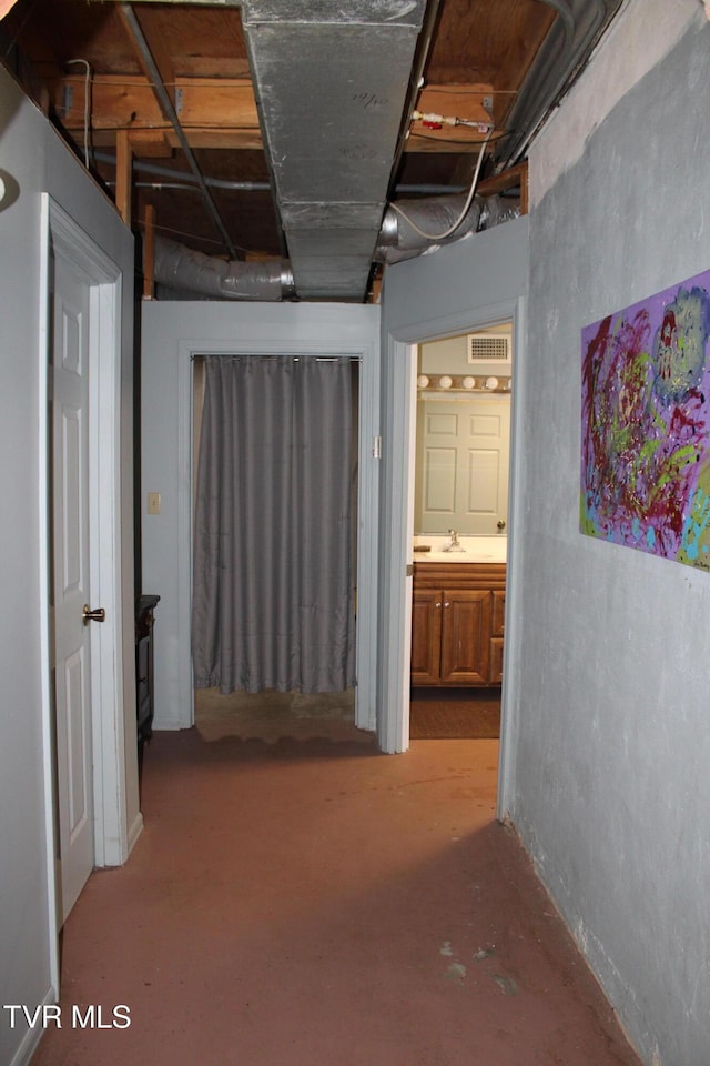 hall featuring concrete floors and sink