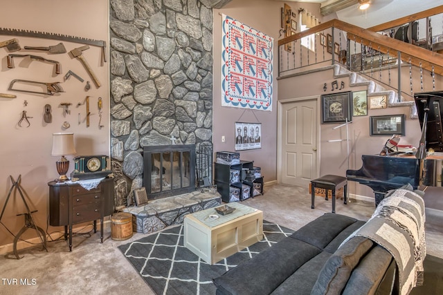 carpeted living room with a fireplace, baseboards, stairs, and a high ceiling