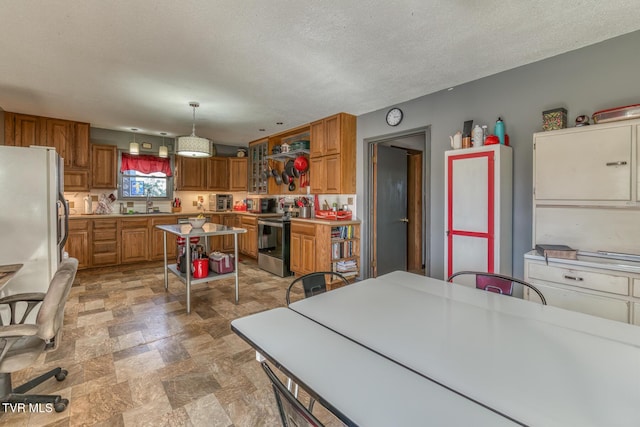 kitchen with stone finish flooring, brown cabinets, stainless steel electric range, and light countertops