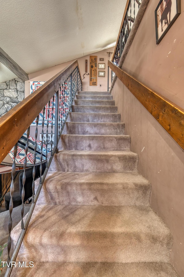 stairway featuring a textured ceiling