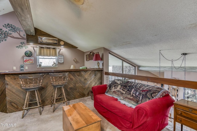 carpeted living room with lofted ceiling, a bar, and a textured ceiling