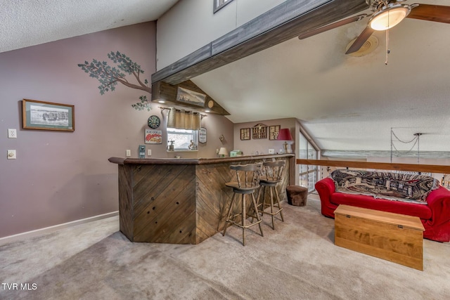 bar featuring ceiling fan, a bar, carpet, and lofted ceiling