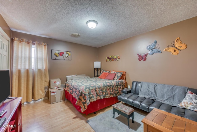bedroom featuring light wood-style flooring and a textured ceiling