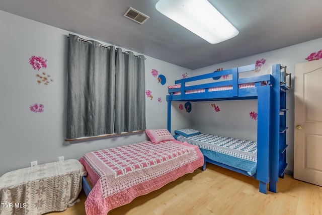 bedroom with visible vents and wood finished floors