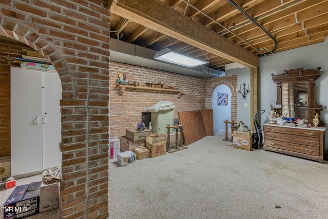 interior space featuring carpet and brick wall