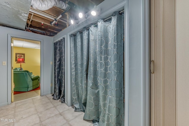 bathroom featuring a shower with shower curtain and baseboards