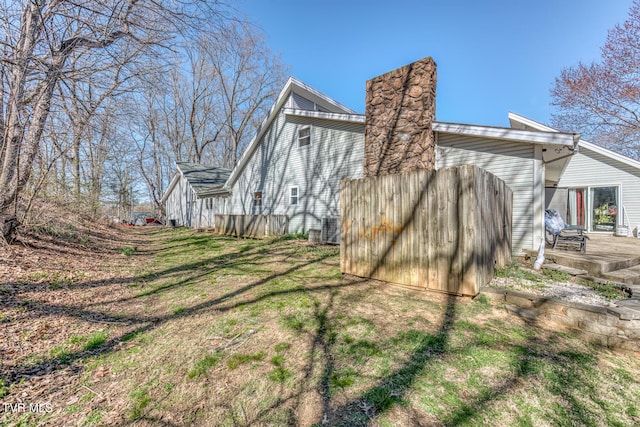 view of property exterior with a lawn and central AC unit
