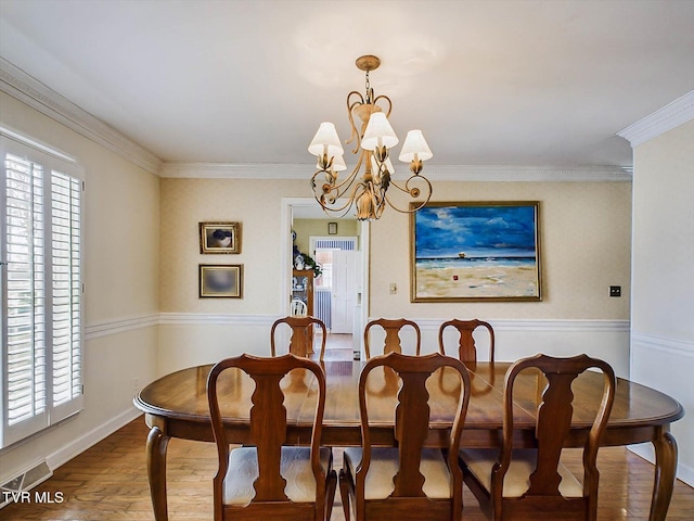 dining area featuring a chandelier, wood-type flooring, and crown molding