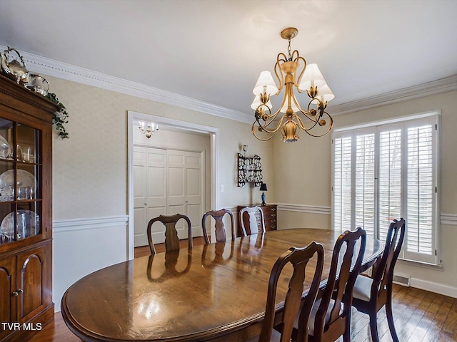 dining room featuring crown molding, dark wood-type flooring, and an inviting chandelier