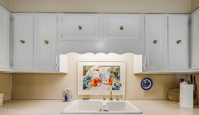 kitchen featuring white cabinets and sink