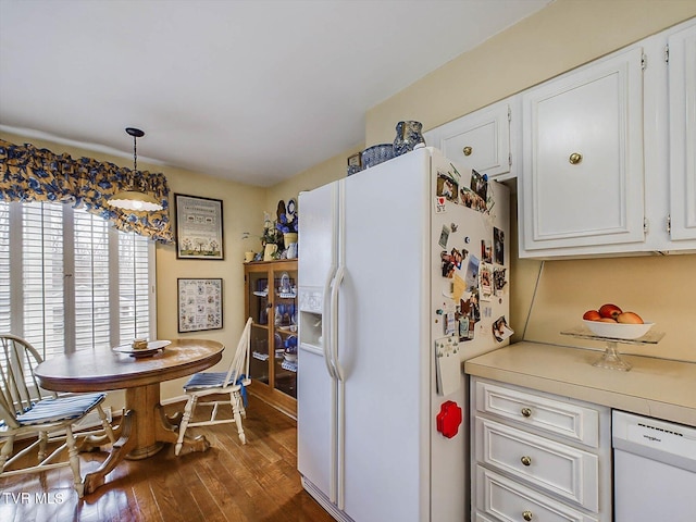 kitchen with dark hardwood / wood-style floors, white cabinets, pendant lighting, and white appliances