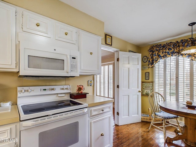 kitchen featuring hanging light fixtures, white cabinets, dark wood-type flooring, and white appliances