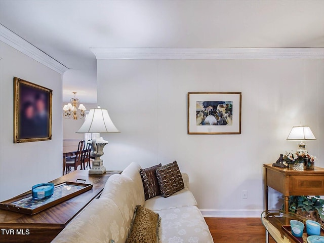 living room with hardwood / wood-style flooring, ornamental molding, and a chandelier