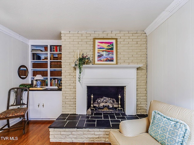 sitting room with dark hardwood / wood-style flooring, crown molding, a fireplace, and wooden walls