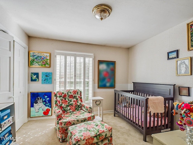 carpeted bedroom with a crib and a closet