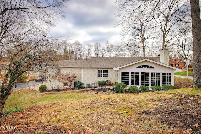 rear view of property featuring a lawn