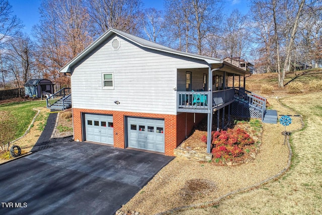 view of property exterior featuring a porch, a garage, and a lawn