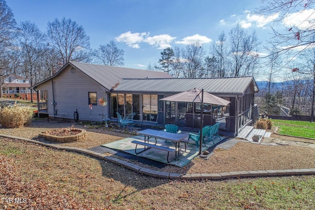 rear view of house featuring a sunroom and a patio area