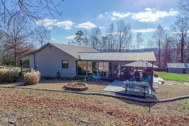 back of property with a patio and a fire pit